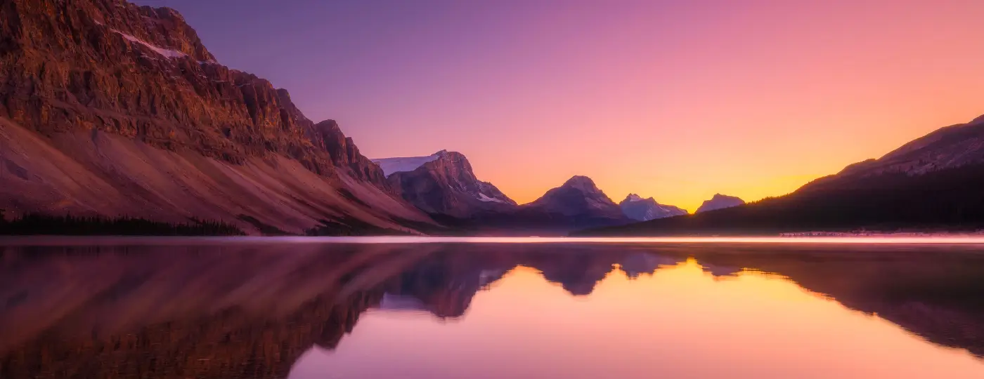 Picture of a beautiful landscape at sunset, showing mountains over a lake